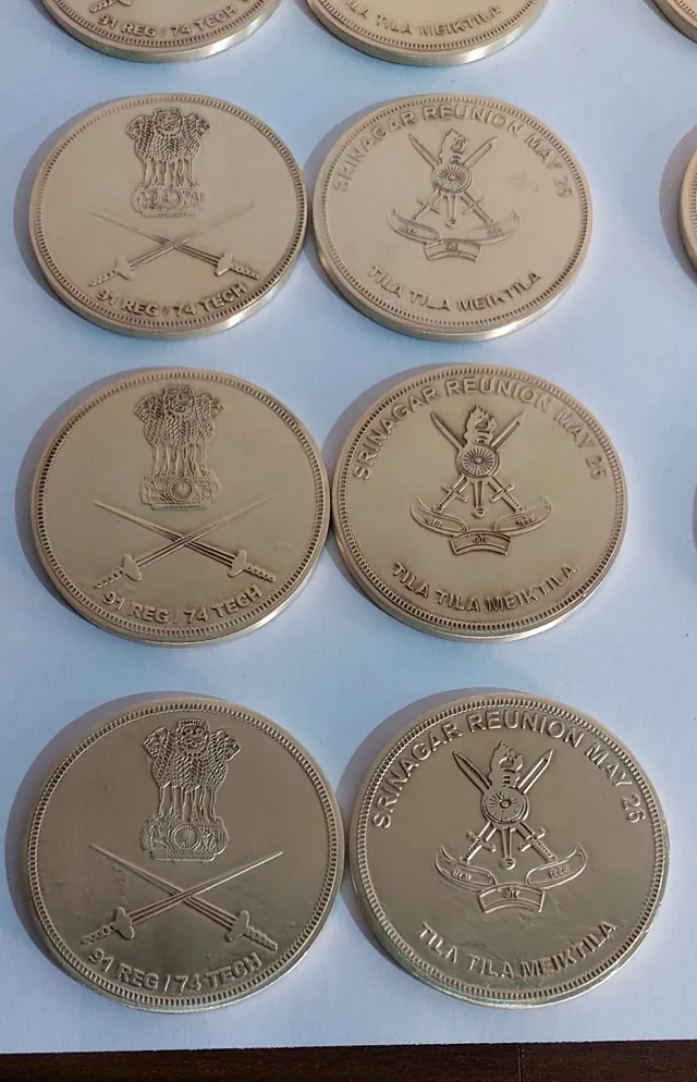 Brass Indian Army coins laid out front and back
