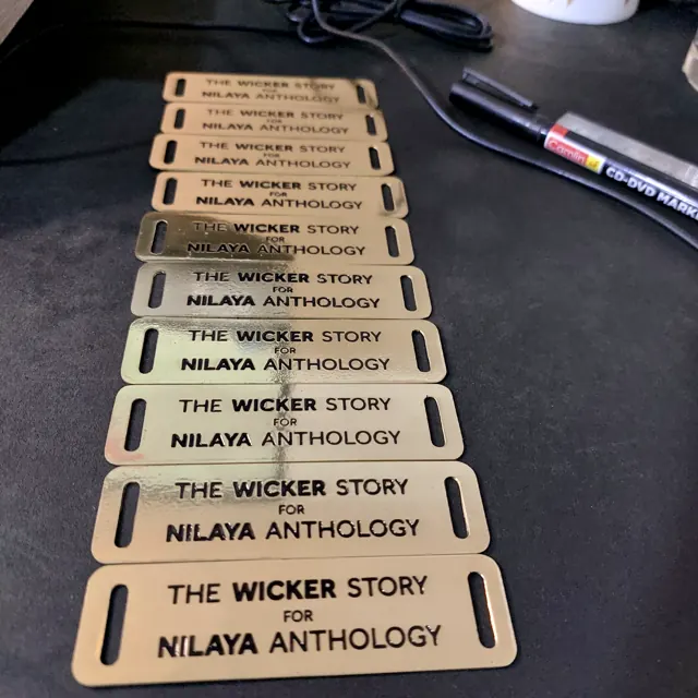 Brass slot labels for The Wicker Story by Nilaya Anthology