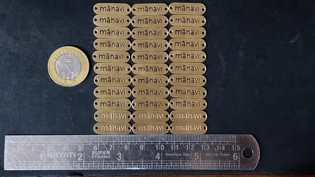 Mahavi brass labels next to a ruler and a one rupee coin for scale