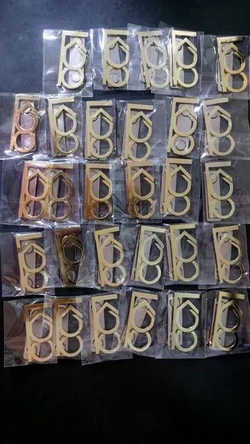 Cut-out brass logo pieces individually packed