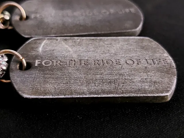 Close-up of For The Ride Of Life engraved on an antique dog tag