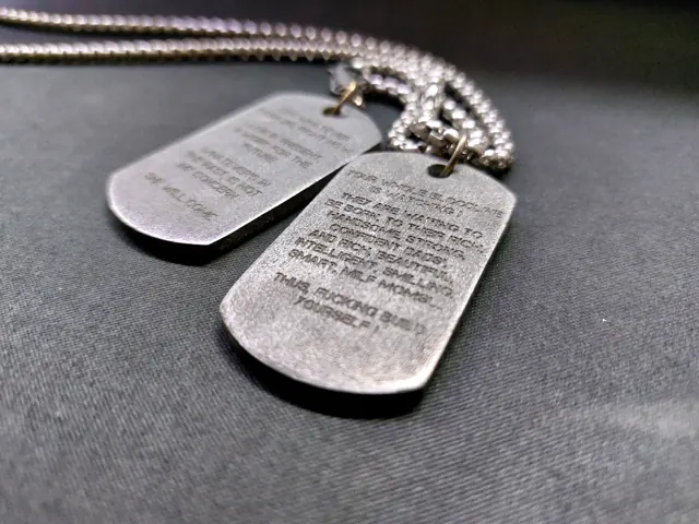 Antique steel dog tags engraved with a motivational text