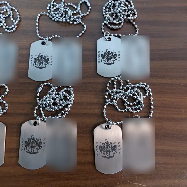 Batch of commando unit dog tags with a horse-mounted warriors emblem; personal names hidden