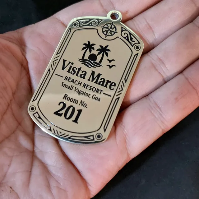 Vista Mare brass room key tag in hand